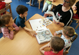 Pani Ania prezentuje dzieciom klaser z ozdobnym papierem ryżowym